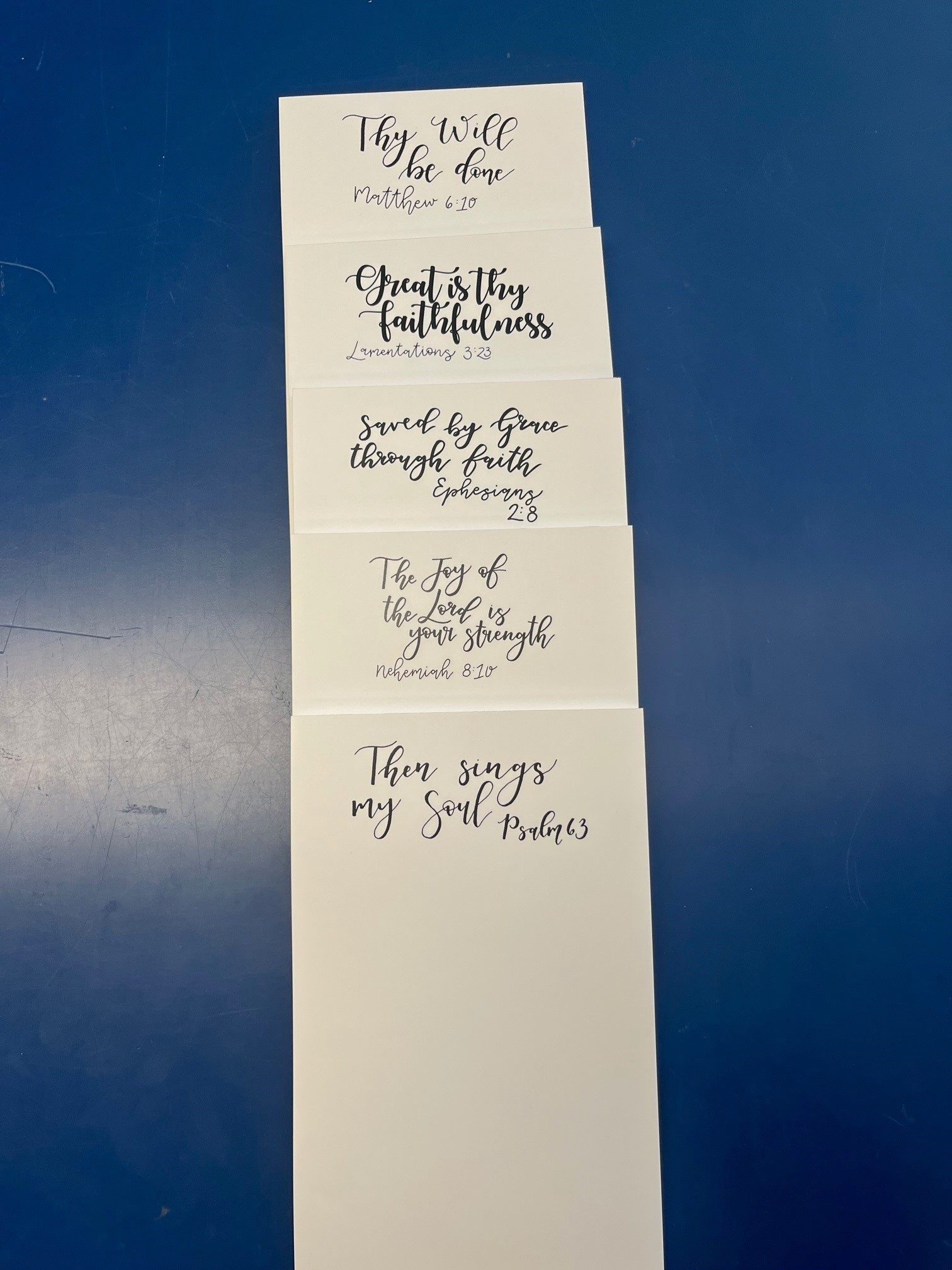 The five Faith notepads stacked in a column, from top to bottom: Thy Will be done, Great is thy faithfulness, Saved by Grace through faith, The Joy of the Lord is your strength, and Then sings my Soul.